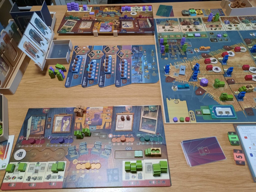 Und eine dritte Speakeasy-Runde. Dieses Mal zeigt das Foto die Karten an der Seite des Spielbretts und den Spielerbereich mit den noch einsetzbaren Gebäuden und Figuren.