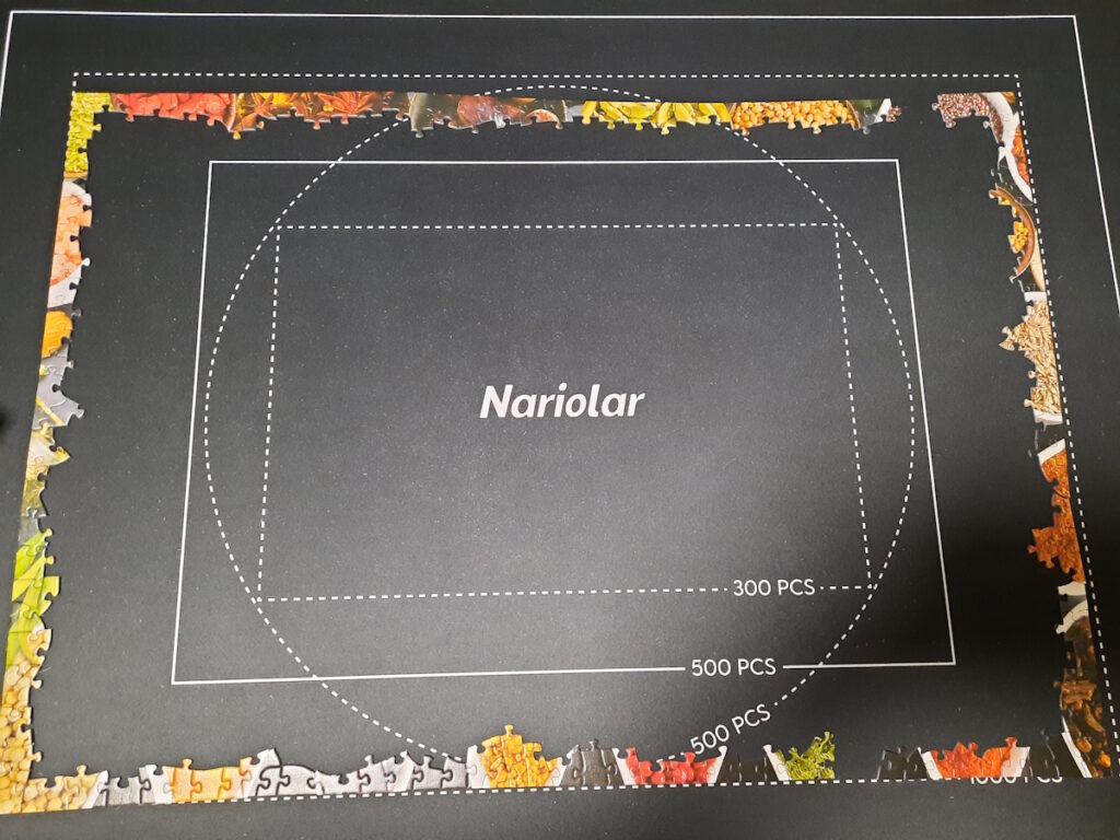 Ein Puzzle, von dem bislang erst der Rand (fast) fertiggestellt wurde auf einer Puzzlematte.