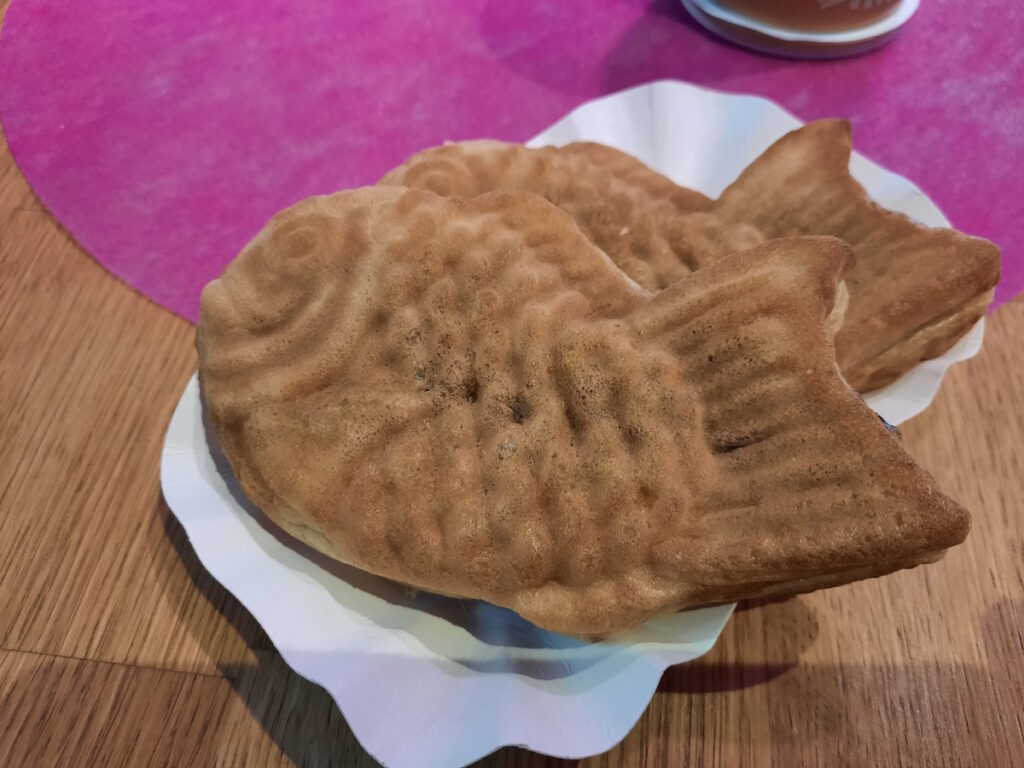 Zwei goldbraune Taiyaki auf einem Papptellerchen.