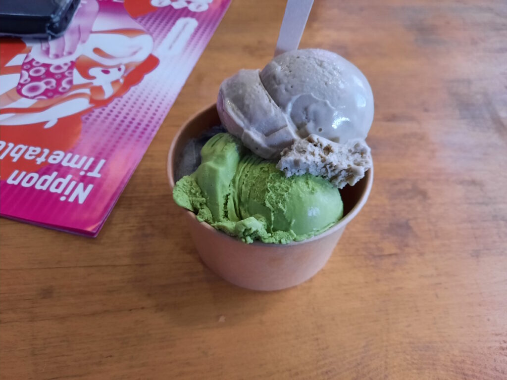 Ein Eisbecher mit Schwarzen-Sesam- und Mochi-Eis. Daneben ist ein Flyer der Nippon Connection zu erahnen.