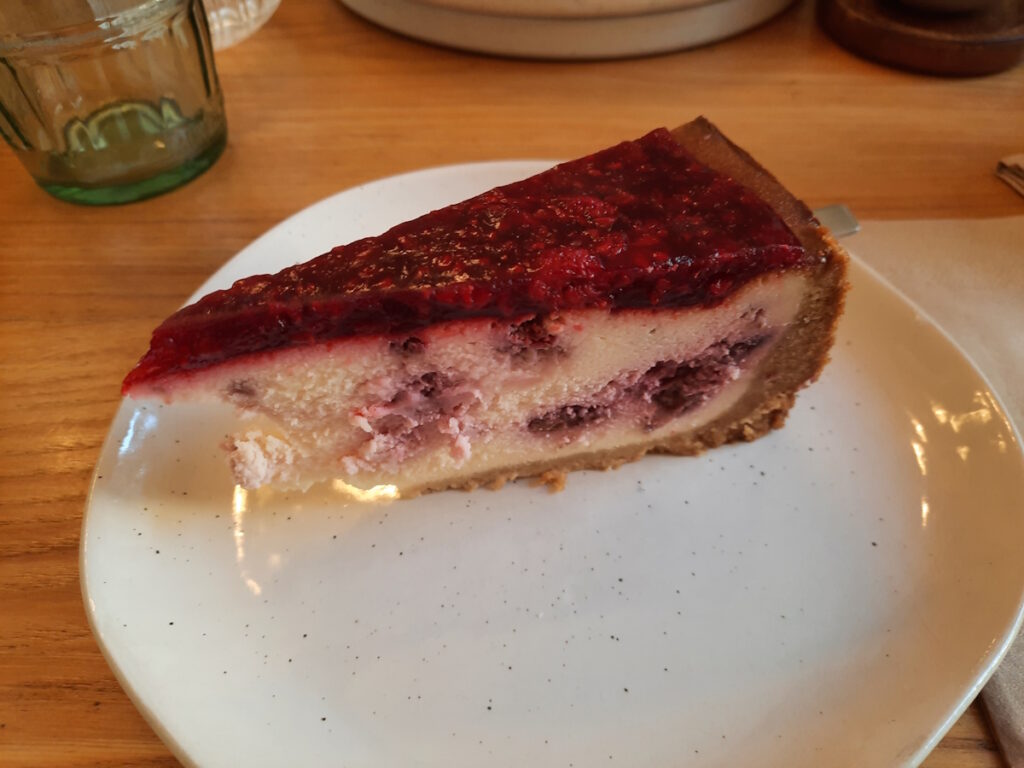 Ein Teller mit einem Stück Himbeer-Käsekuchen.