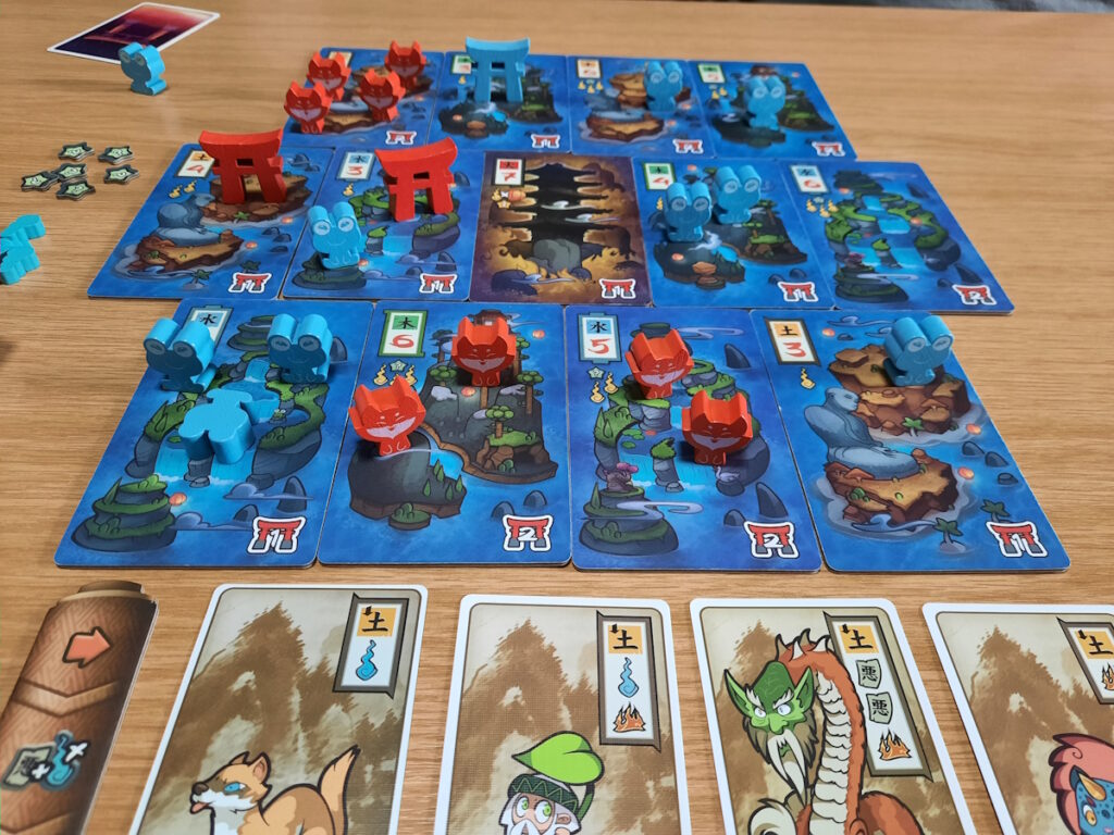 Eine Nahaufnahme des Spielbretts, bei der Fuchsfiguren (meine Spielfiguren) und Frösch (die Figuren von meinem Mann) auf dem Spielbrett verteilt zu sehen sind. An manchen Stellen des Spielbretts stehen Torii.